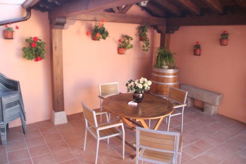 a patio with a wooden table and chairs and plants at La Casa Madrona in Villacastín