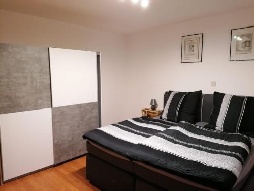 a bedroom with a bed with black and white pillows at Enscher Stübchen Wohnung Katharina in Ensch