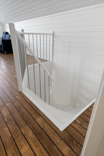 a white staircase in a room with wood floors at Flott sjøhus rett ved Saltstraumen in Saltstraumen