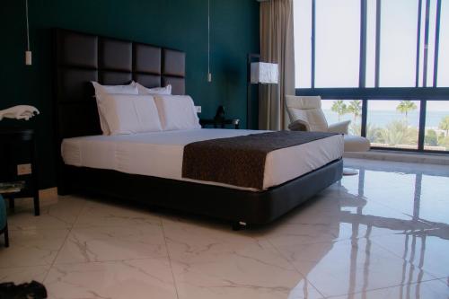 a bedroom with a large bed and a large window at Hotel Por Do Sol in Tarrafal