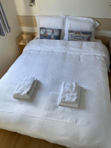 a white bed with two folded towels on it at CHALET UP TO 5 PERSONS KNOKKE in Knokke-Heist