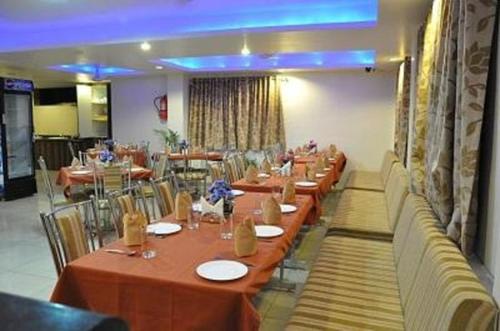 eine Reihe von Tischen in einem Restaurant mit Stühlen in der Unterkunft JK Rooms 147 Lions - Koradi Nagpur in Nagpur