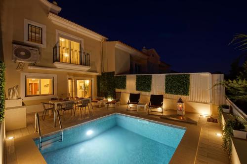 a swimming pool in front of a house at night at Eagle Eye Villa in Albufeira