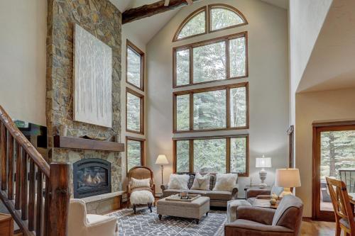 a living room with a fireplace and a stone wall at Arrowhead Village at Beaver Creek in Edwards