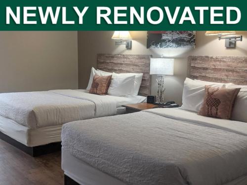 two beds in a hotel room with the words newly renovated at Abe Martin Lodge & Cabins in Nashville