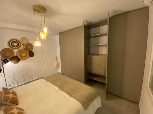 a bedroom with a white bed and a closet at Le Jardin Caché in Sanary-sur-Mer