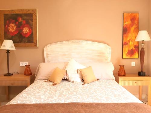 a bedroom with a white bed with two lamps at Casa solis in Leganés