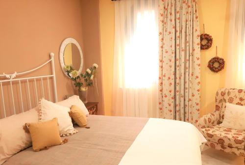 a bedroom with a bed and a chair and a window at Casa solis in Leganés