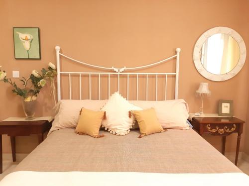 a bedroom with a bed with pillows and a mirror at Casa solis in Leganés