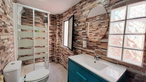 a bathroom with a toilet and a sink and a mirror at Casa solis in Leganés