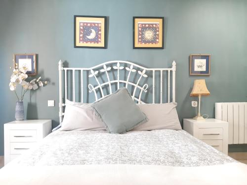 1 dormitorio con 1 cama blanca y paredes azules en Casa solis, en Leganés