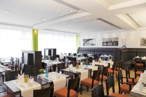 a dining room filled with tables and chairs at SOALTEE Hotel by Trip Inn Frankfurt Messe Tagungshotel in Frankfurt/Main