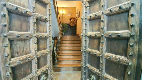 a pair of wooden doors in a hallway with stairs at Casa solis in Leganés