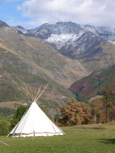 a white teepee in a field with mountains in the background at Tipi nature double in Gavarnie