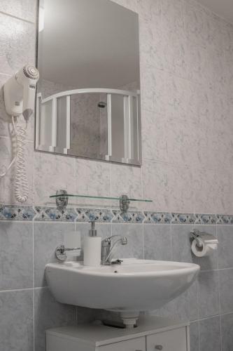 a bathroom with a sink and a mirror at Penzion Pohoda in Frymburk