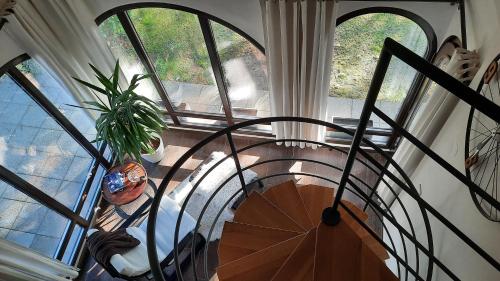 a spiral staircase in a house with a plant at Spacious Apartment "Ana" on lake Sabljaci in Ogulin