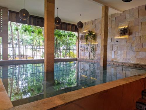 a swimming pool with a large window in a building at Sanctuary Pirenópolis Suítes e Flats in Pirenópolis