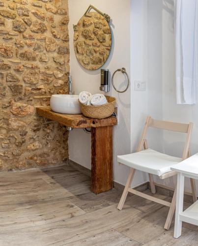 a bathroom with a table with a mirror and a chair at Knysna Boutique Rooms in Peniscola