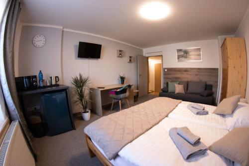 a hotel room with a large bed and a desk at Penzion Pohoda in Frymburk