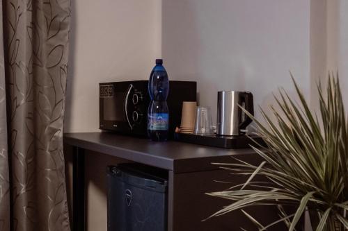 a bottle sitting on top of a table with a microwave at Penzion Pohoda in Frymburk