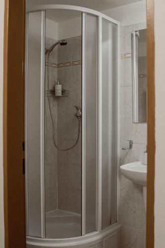 a shower with a glass door in a bathroom at Penzion Pohoda in Frymburk