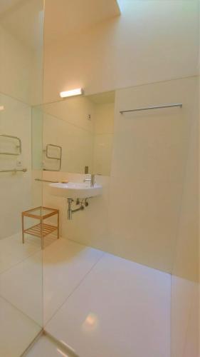 a white bathroom with a sink and a mirror at Convento Bernardas duplex BL - 3 bedroom in Tavira