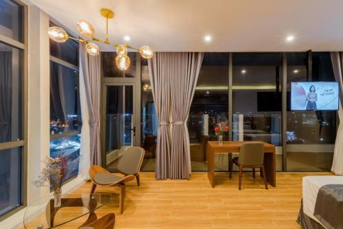 a living room with a table and chairs and a window at The Empire Hotel in Phu Quoc