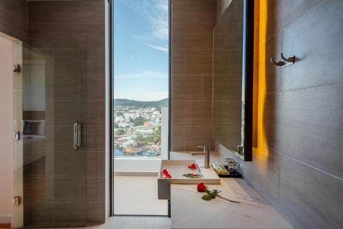a bathroom with a shower and a sink with a window at The Empire Hotel in Phu Quoc