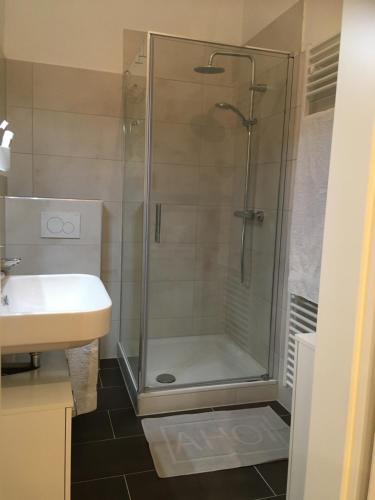 ein Bad mit einer Dusche und einem Waschbecken in der Unterkunft City-Apartment Ohligs in Solingen