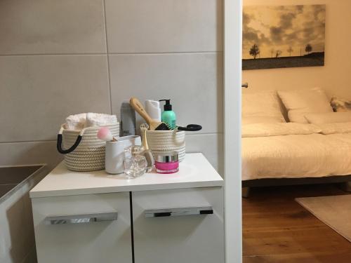 a table with bottles and baskets on it with a bed at City-Apartment Ohligs in Solingen