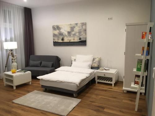 a living room with a bed and a chair at City-Apartment Ohligs in Solingen