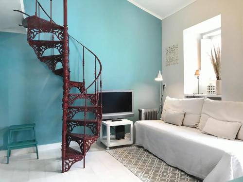 ein Wohnzimmer mit einem Bett und einer Wendeltreppe in der Unterkunft Riverside Apartment 42 - Lisbon in Lissabon