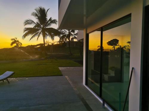 a view of the sunset from a house with a window at Ocean Breeze Cove - Luxury Retreat in Pedasí Town