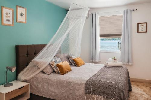 1 dormitorio con 1 cama con mosquitera en Bonito Paraiso Ilha Grande en Ilha Grande