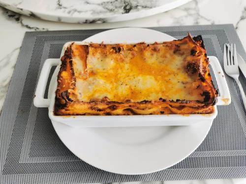 a casserole in a white dish on a table at Ocean Breeze Cove - Luxury Retreat in Pedasí Town