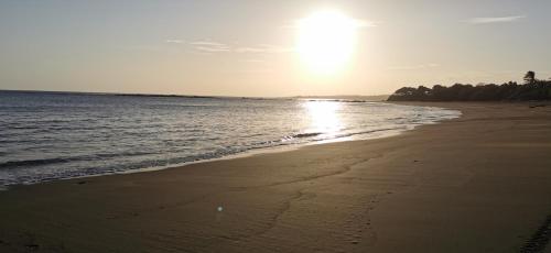 a beach with the sun shining on the water at Ocean Breeze Cove - Luxury Retreat in Pedasí Town