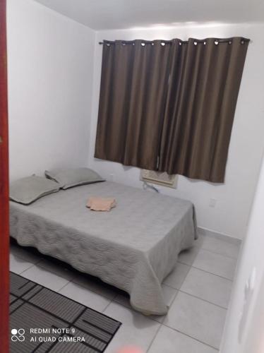 a bedroom with a bed and a window with a curtain at Apartamento ao lado Shopping in Campos dos Goytacazes