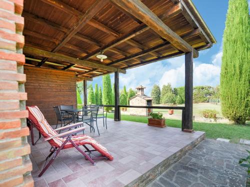 un patio con sillas, una mesa y una pérgola de madera en Belvilla by OYO Chiaradue, en Acquaviva