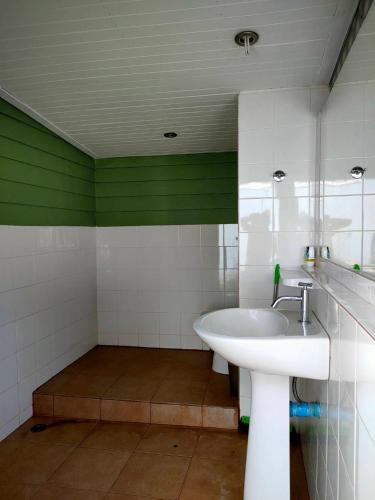 a bathroom with a sink and a green wall at Pran sea & sun 2 in Pran Buri
