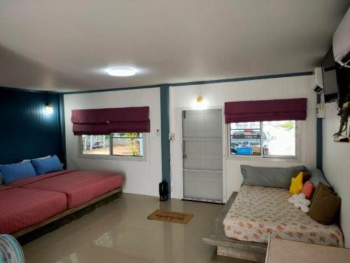 a living room with two beds and a window at Pran sea & sun 2 in Pran Buri