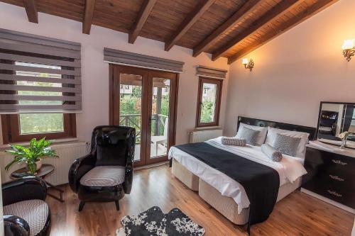 una camera da letto con un letto, una sedia e finestre di MyHomeSapanca a Sapanca