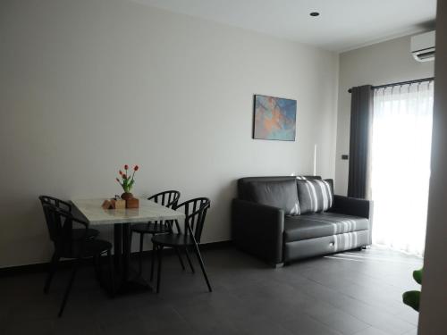 a living room with a table and a couch at Toledo Pool Villa in Nakhon Si Thammarat