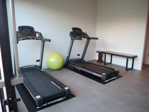 a gym with two tread machines and a ball and a table at Toledo Pool Villa in Nakhon Si Thammarat