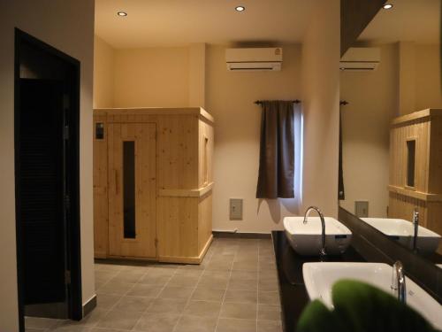 a bathroom with two sinks and a wooden cabinet at Toledo Pool Villa in Nakhon Si Thammarat