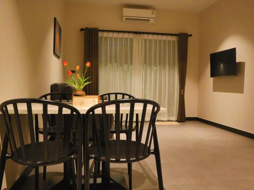 a dining room with a table and chairs and a television at Toledo Pool Villa in Nakhon Si Thammarat
