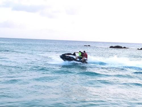 a group of people riding on a jet ski in the ocean at 海灘戀情 Beach Love 近沙灘-國旅卡特約商店 陽台房 希臘地中海風格 in Eluan