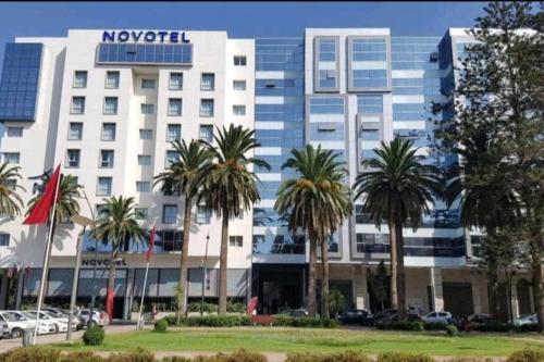 a hotel with palm trees in front of a building at CENTRAL VIP STUDIO appartement in Mohammedia