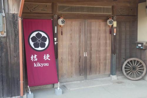 a front door of a building with a kiwi sign on it at 民泊 桔梗 in Awaji