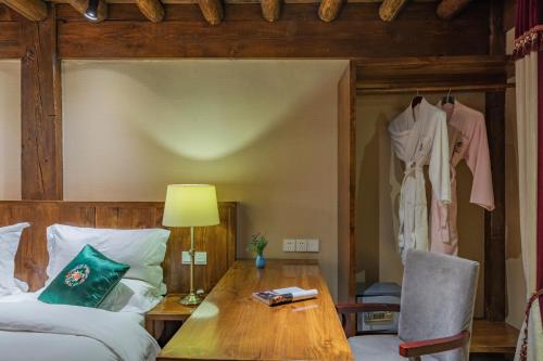 a bedroom with a bed and a desk and a table at Arro Khampa By Zinc Journey Shangri-la in Shangri-La