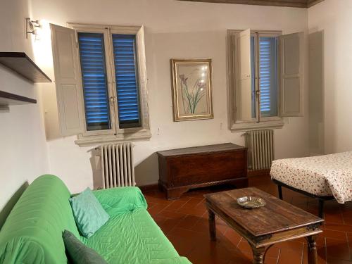 a living room with a green couch and a table at Fiesolana 26 in Florence